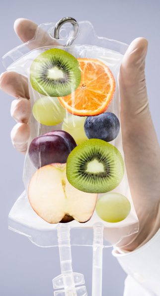 Male Doctor Holding Saline Bag With Fruit Slices Inside In Hospital